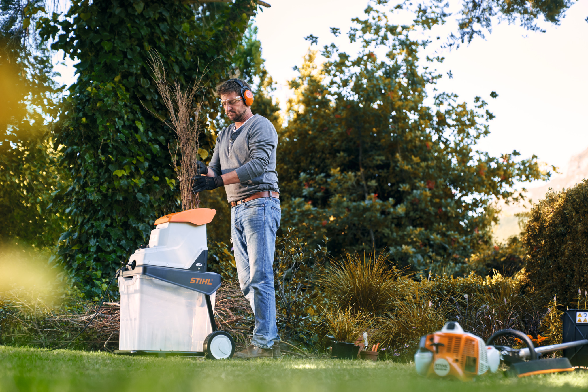 Man chops branches in garden with STIHL GHE 140