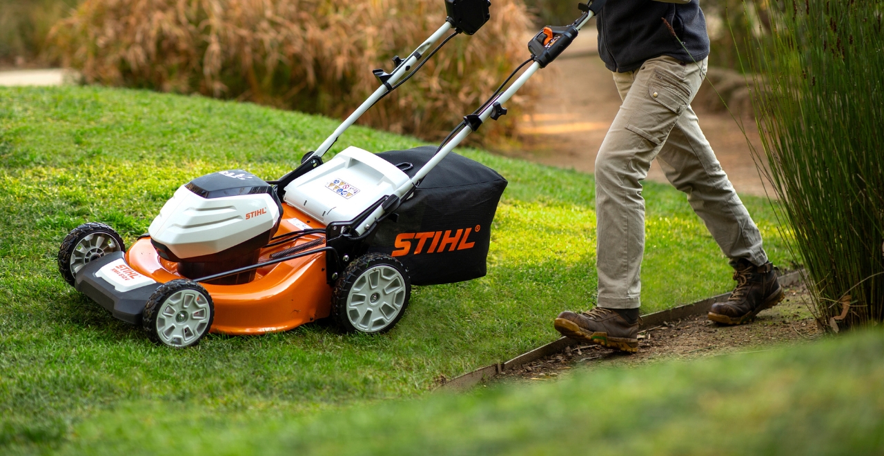 a person uses a STIHL lawn mower on a garden