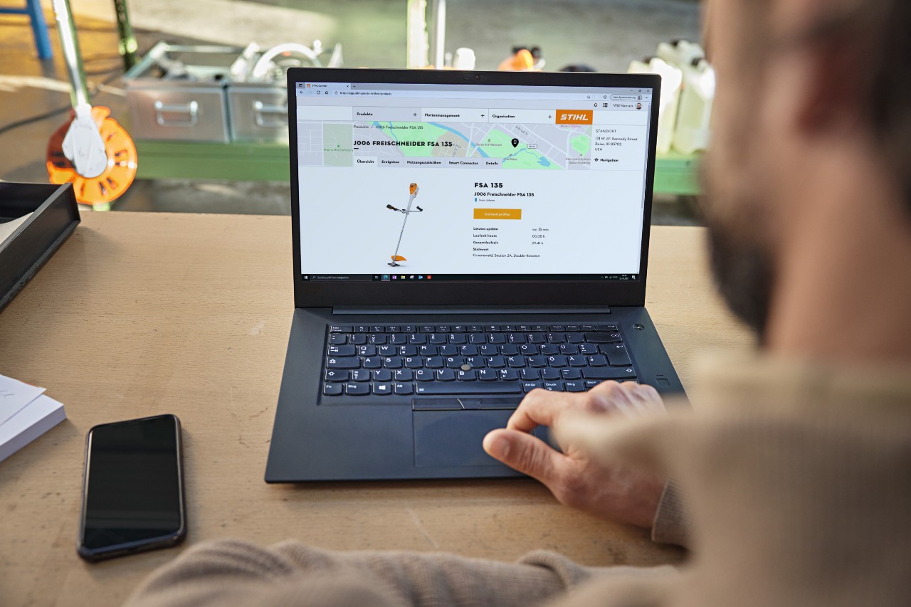 Mann sitzt vor dem aufgeklappten Laptop und prüft den Gerätestand bei STIHL connected