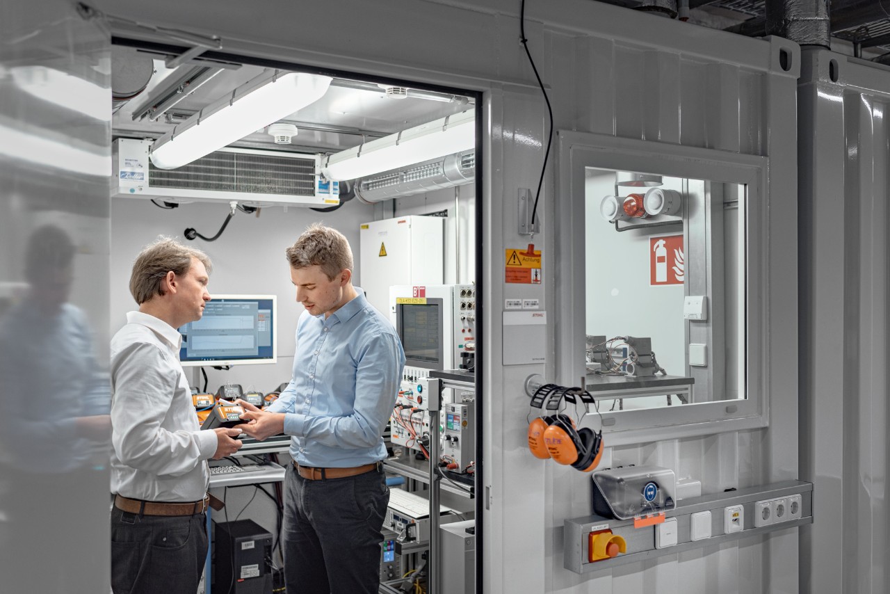 Two men in a test area for battery packs 