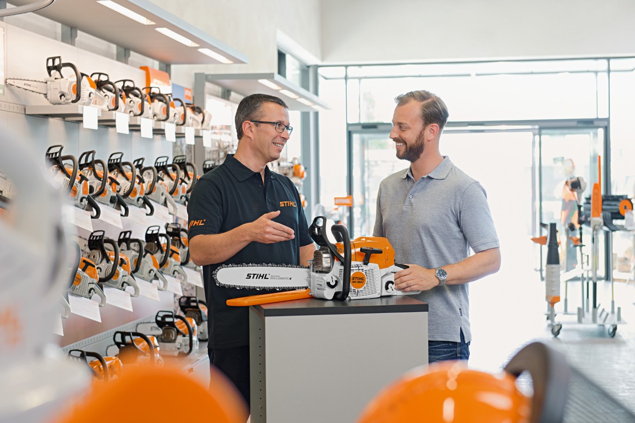 A man talking to a STIHL dealer about a STIHL chainsaw 