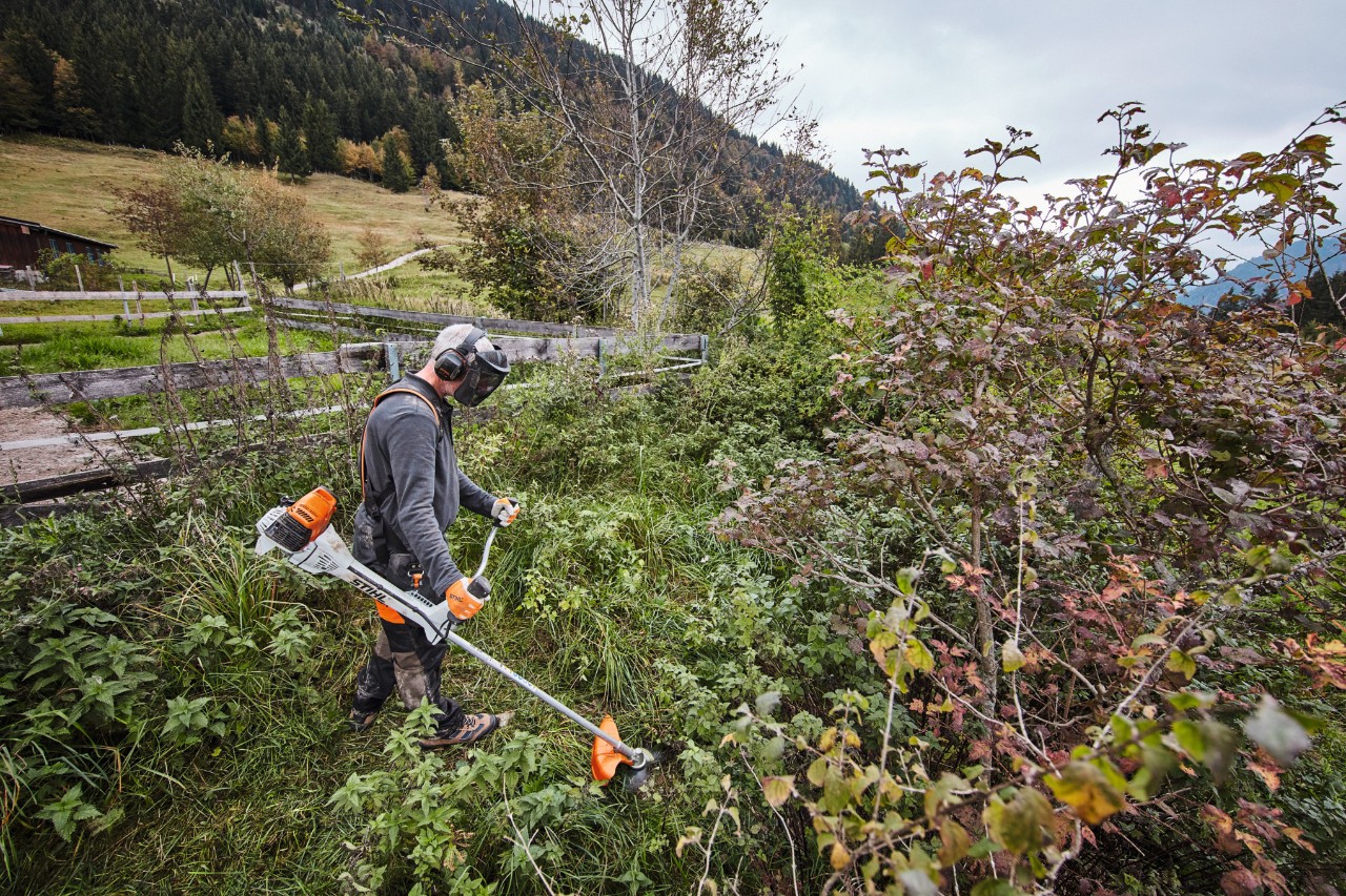 Man in protective gear mowing dense scrub with a STIHL FS 311 petrol-driven clearing saw