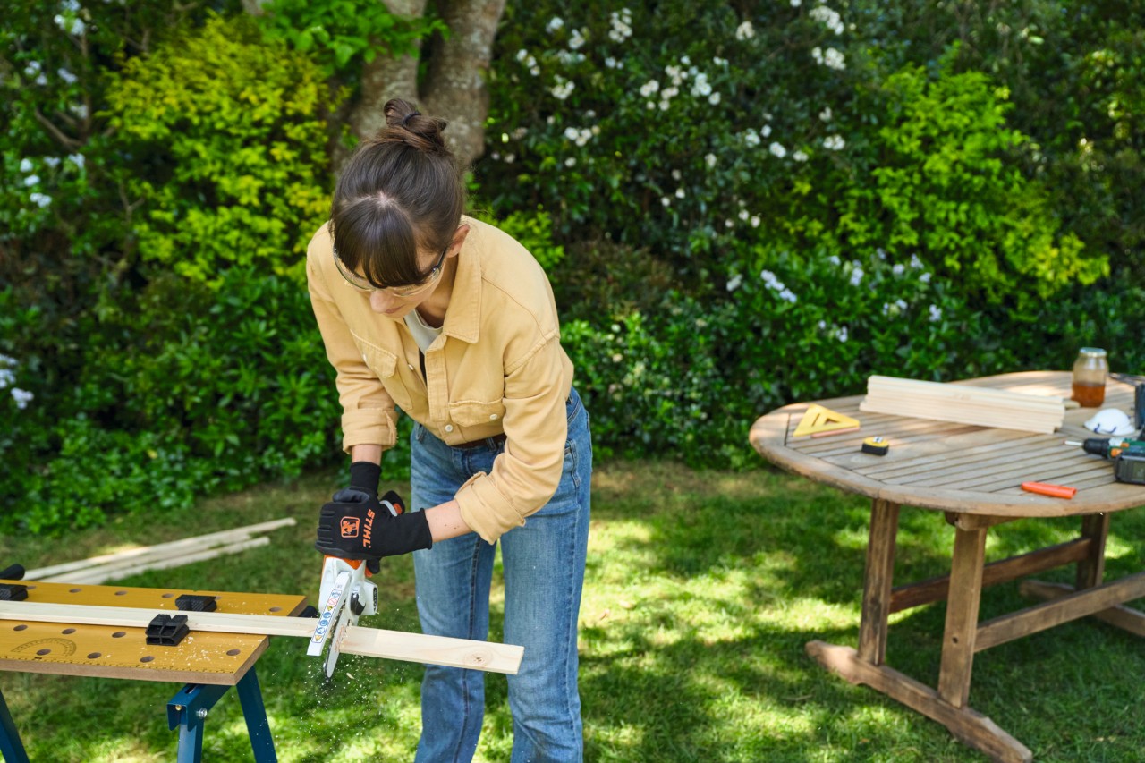 A woman sawing a strip with the STIHL GTA 26 garden pruner