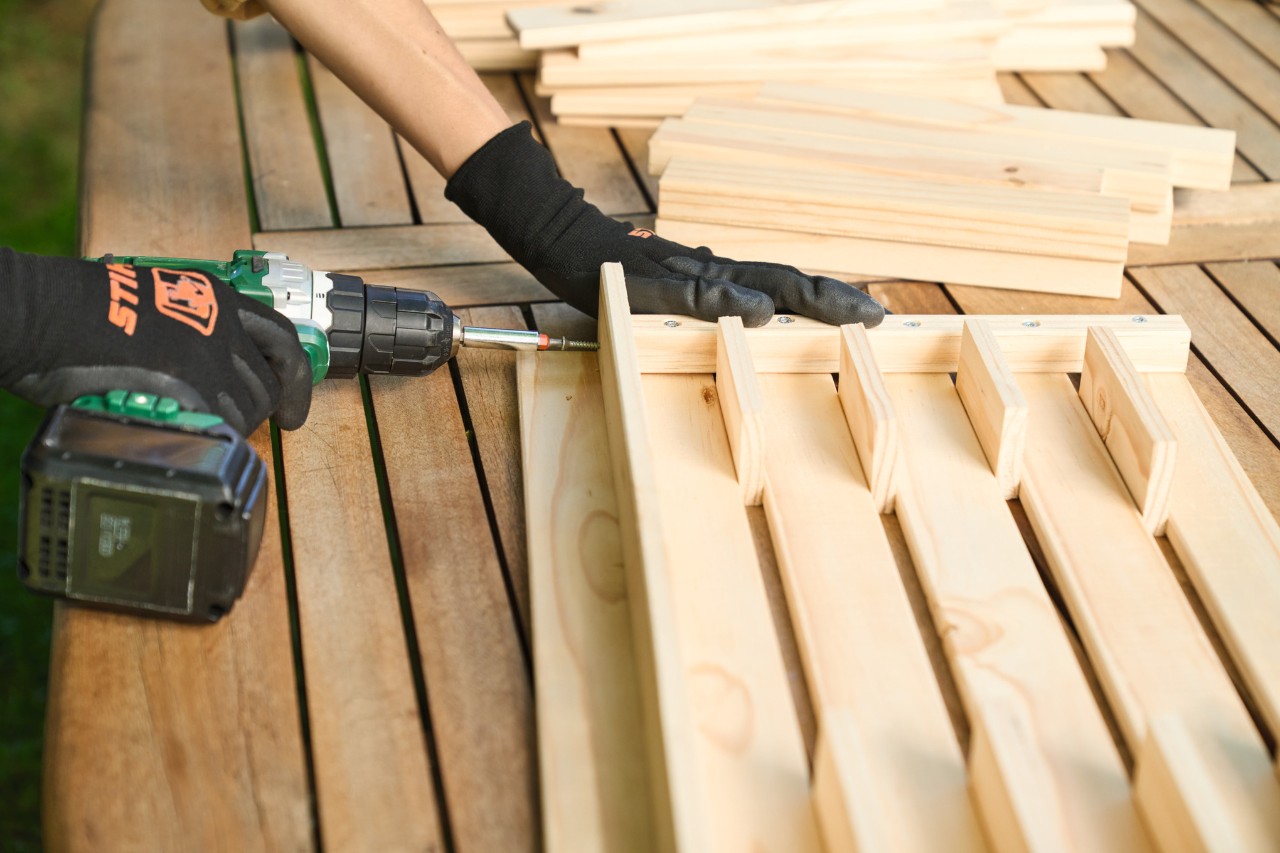 Someone screwing the square-edged timbers and floor strips together