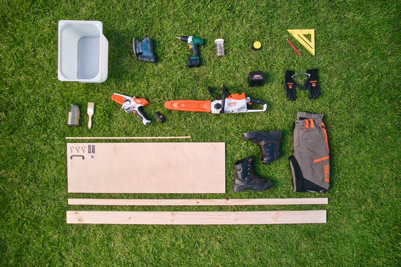 Materials and tools for building a potting bench laid out on a lawn, including the STIHL MSA 140 C cordless chainsaw and the STIHL GTA 26 garden pruner