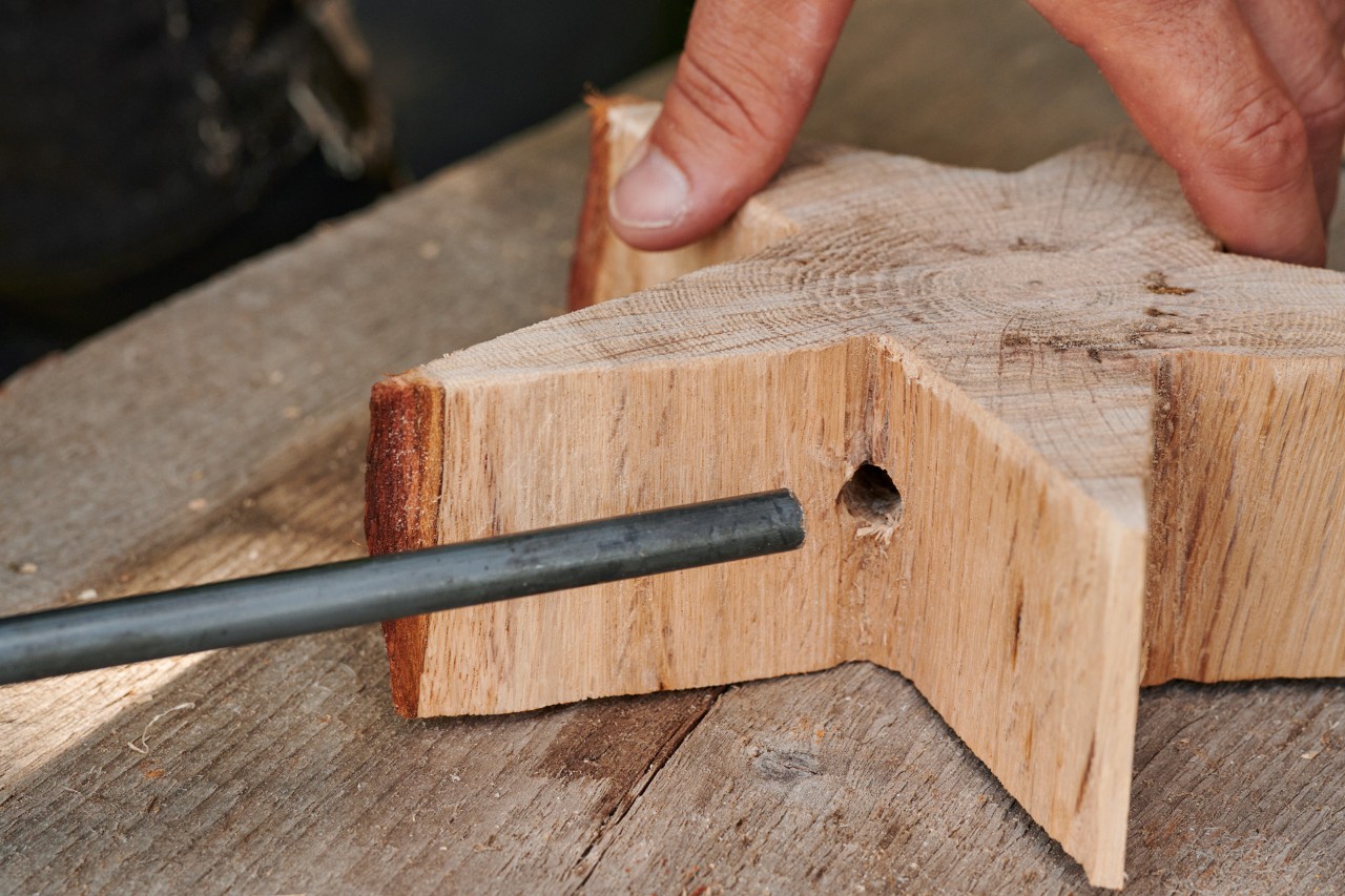 A metal stick being inserted into a wooden star