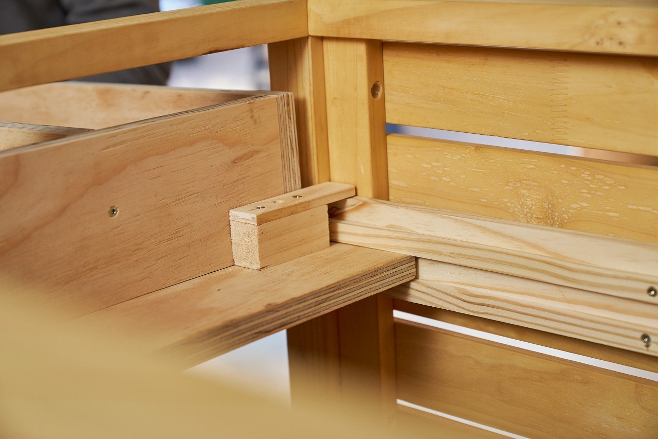 DIY drawer with stoppers made from offcuts for the lawn mower storage box