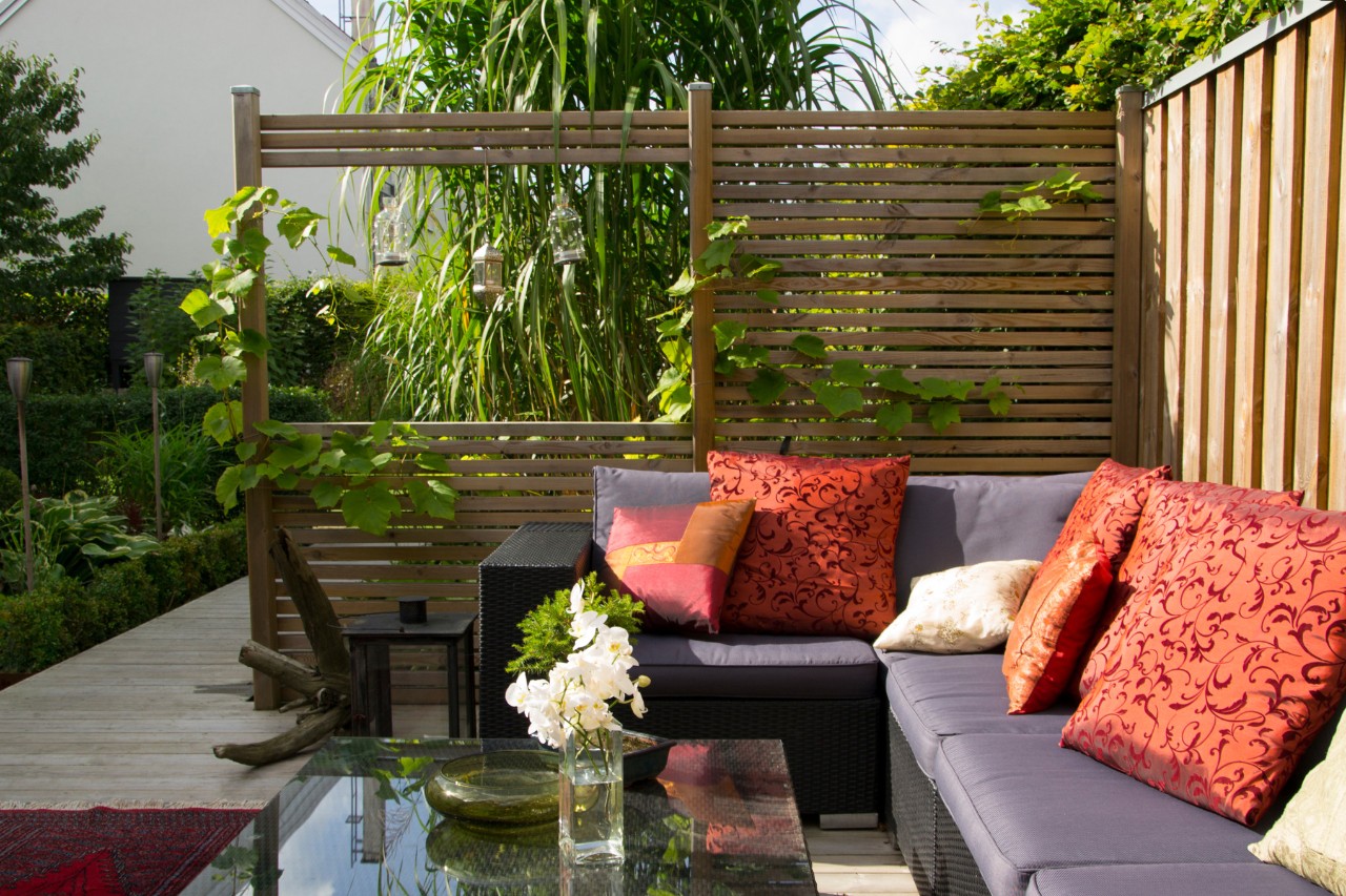 Modern terrace with a couch and a wooden privacy screen 