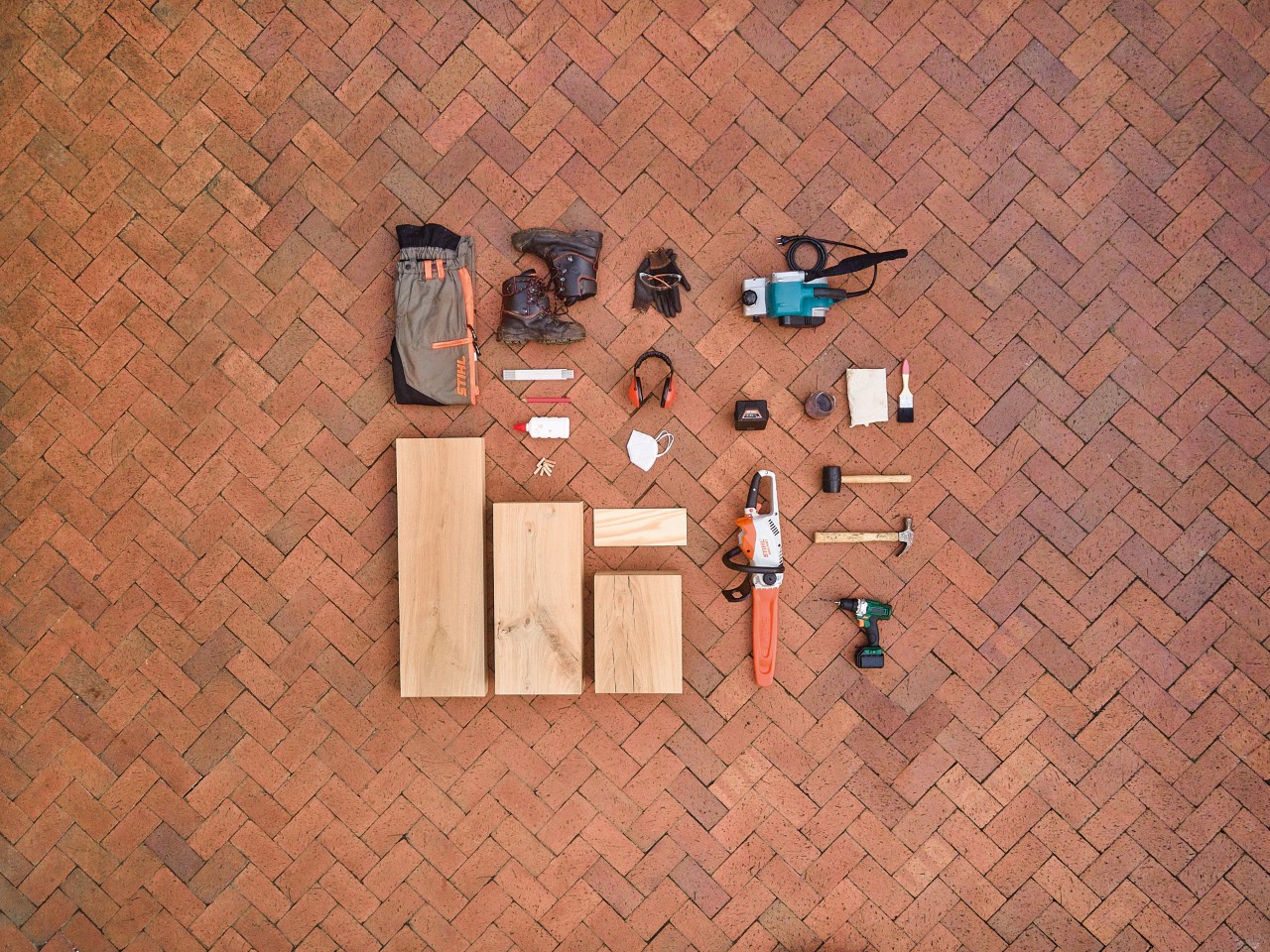 STIHL protective equipment, wooden beams and STIHL tools, including STIHL MSA 140 C cordless chainsaw, lie on the ground