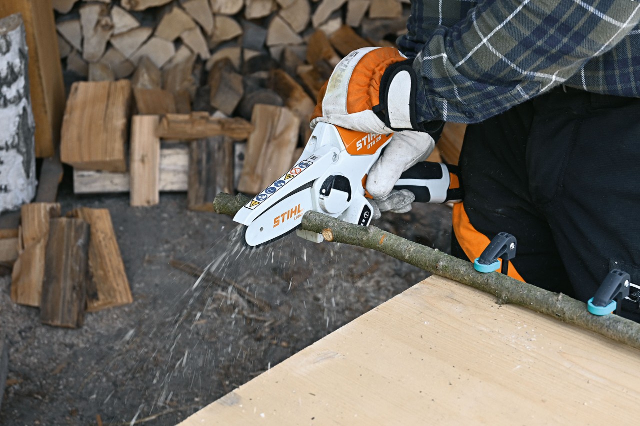 Close-up of a person cutting a branch with the STIHL GTA 26 cordless garden pruner