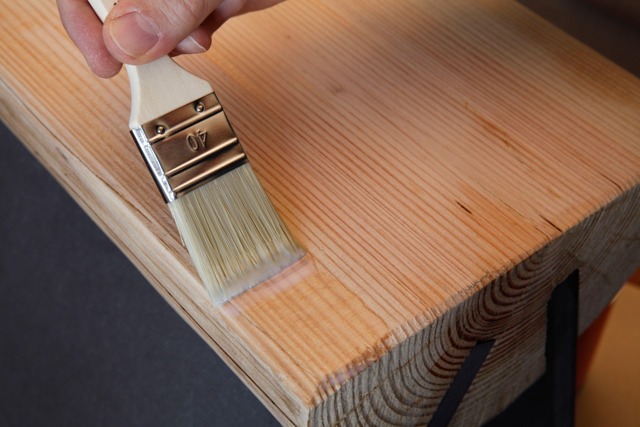 Wood varnish being applied with a brush to a prepared wood surface