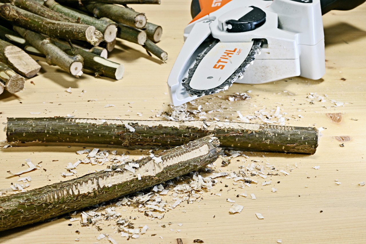 DIY table lamp from twigs: branches with roughened surfaces, with a STIHL GTA 26 cordless garden pruner behind them