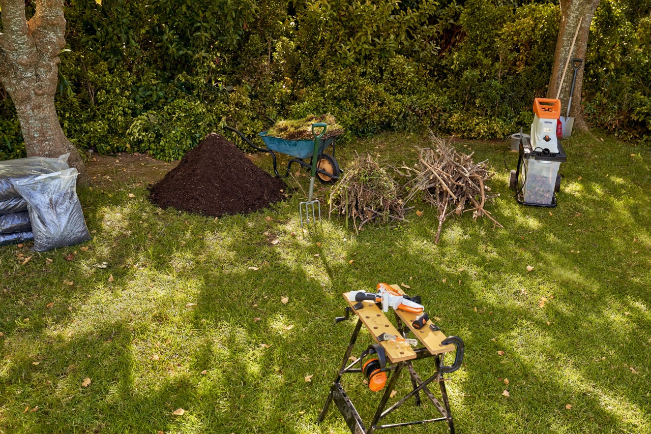 Materials for filling a raised bed: a STIHL GHE 140 electric garden shredder, cuttings and compost in a garden