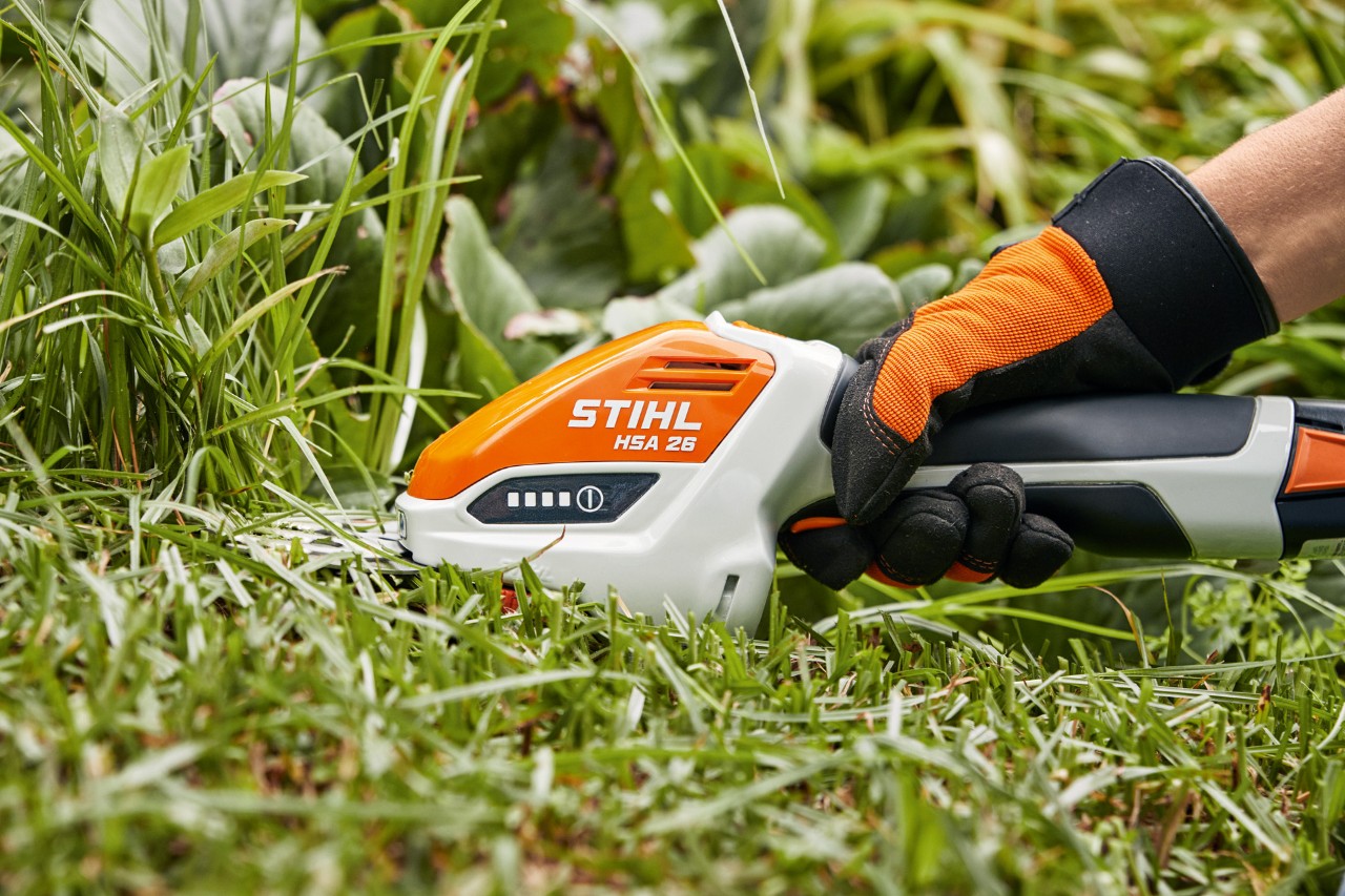 STIHL HSA 26 cordless garden shears being used for trimming grass