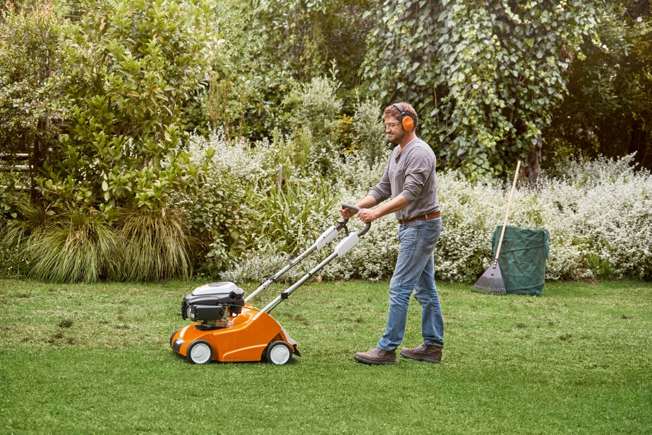 Man scarifies green lawn with a STIHL RL 540 scarifier