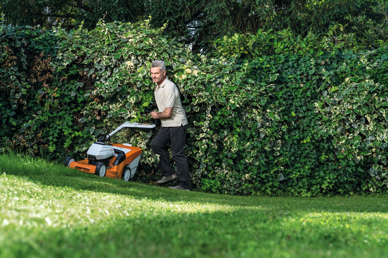 A man mowing a slope with a STIHL RMA 448 TC cordless lawn mower  