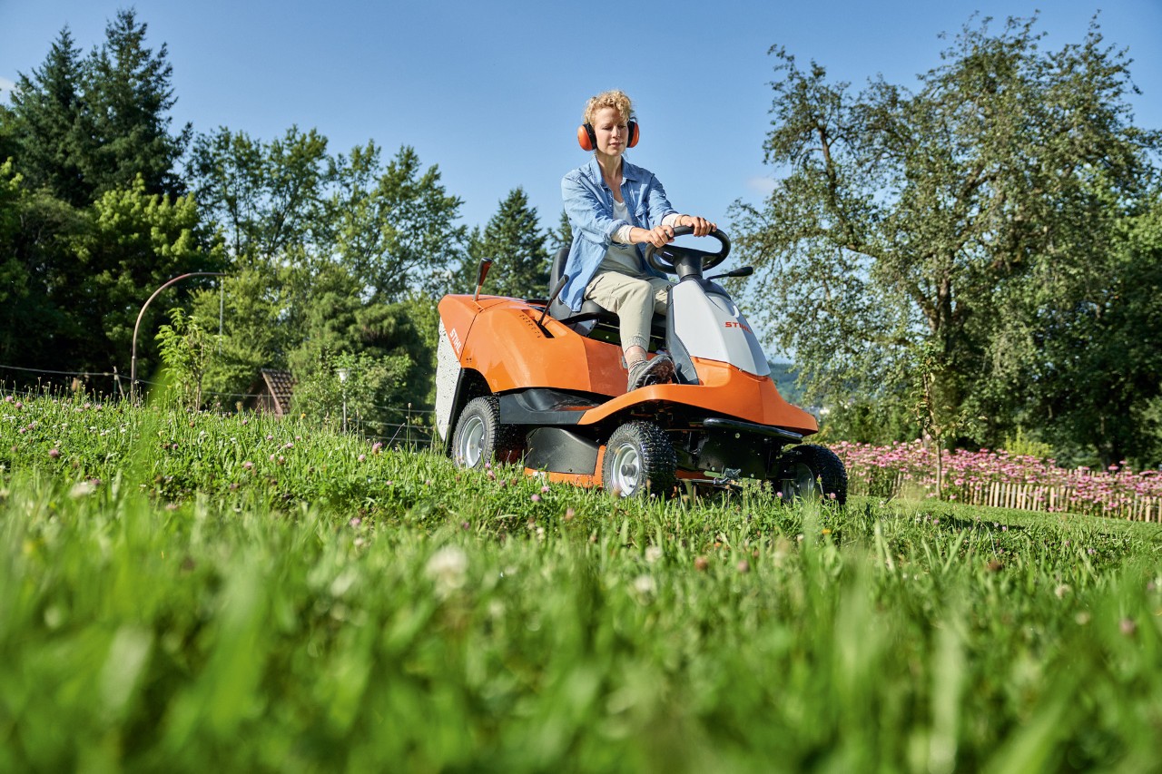 A woman mowing a slope with a STIHL RT 4082 ride-on mower 