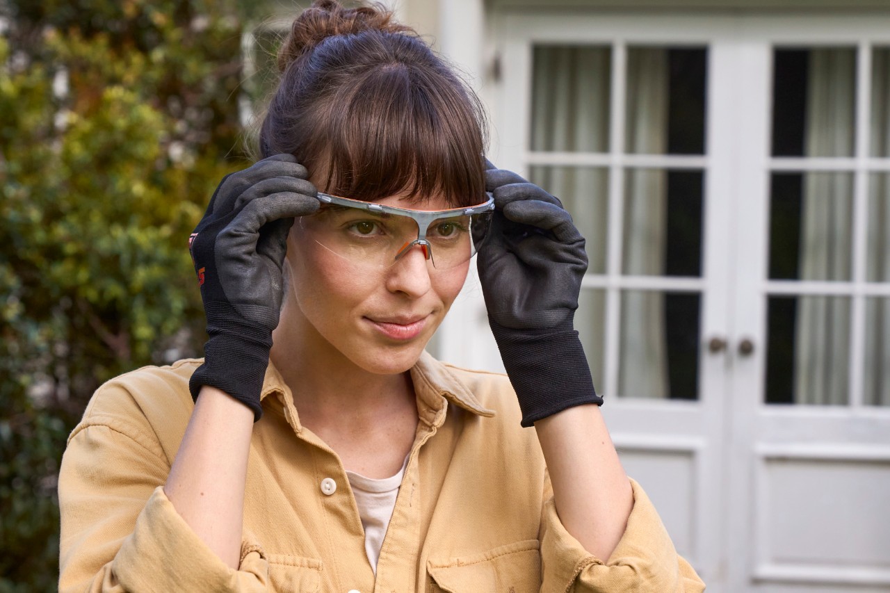 A woman putting on her safety glasses