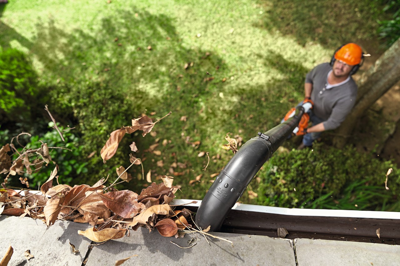 A man cleaning gutters with a STIHL gutter cleaning set