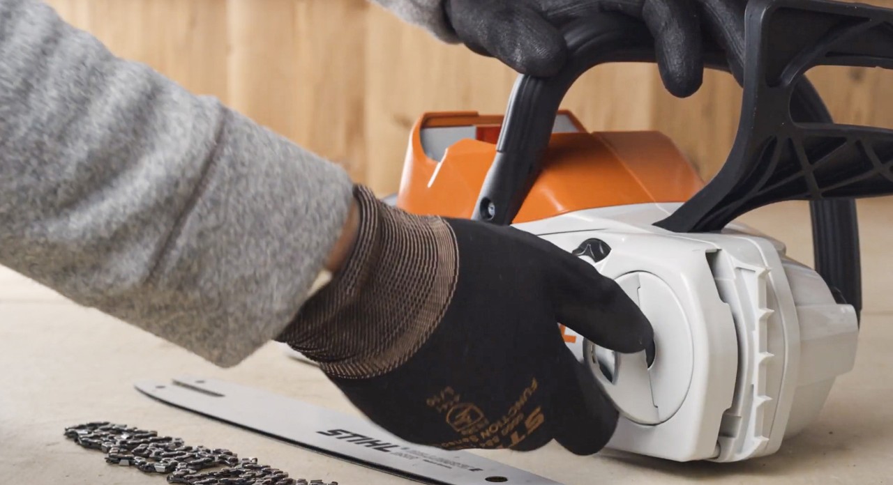 The chain sprocket cover of a STIHL MSA 120 cordless chainsaw being removed