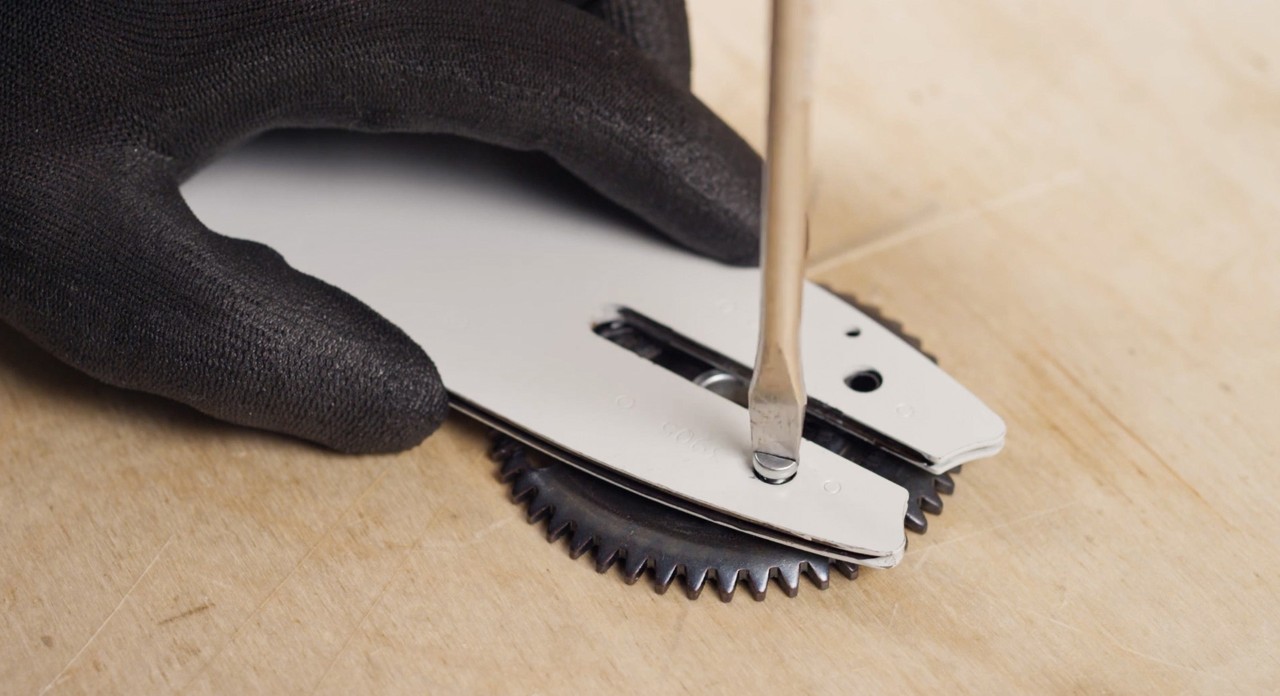Close-up of a tensioning gear being fitted to a guide bar 