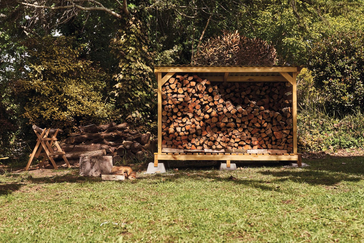 Outdoor firewood storage shed situated on a garden plot