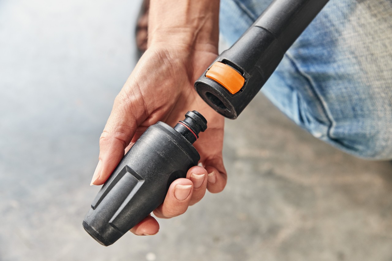  A person mounting an attachment on a STIHL RE 130 PLUS high-pressure cleaner to use it